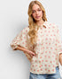 Woman wearing a floral blouse with a plain background