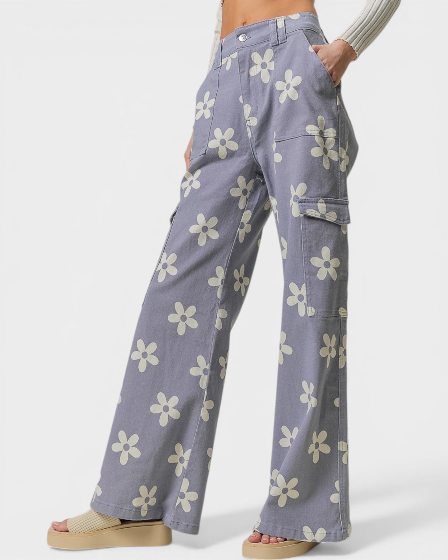 Person wearing purple cargo pants with white floral patterns on a white background