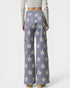 Purple floral-patterned pants worn by a person on a white background