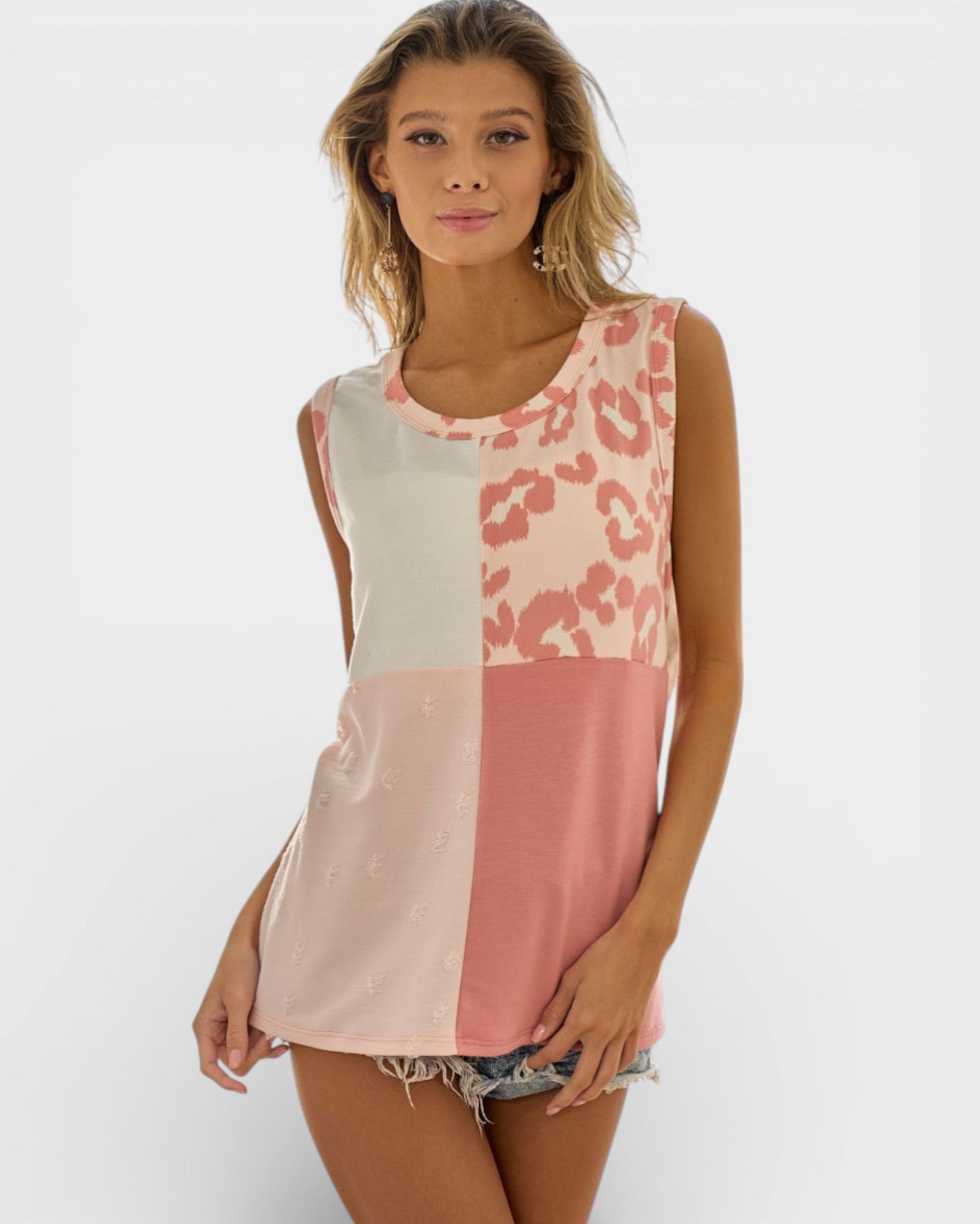 Woman wearing a sleeveless top with color-block design and pink leopard print pattern.
