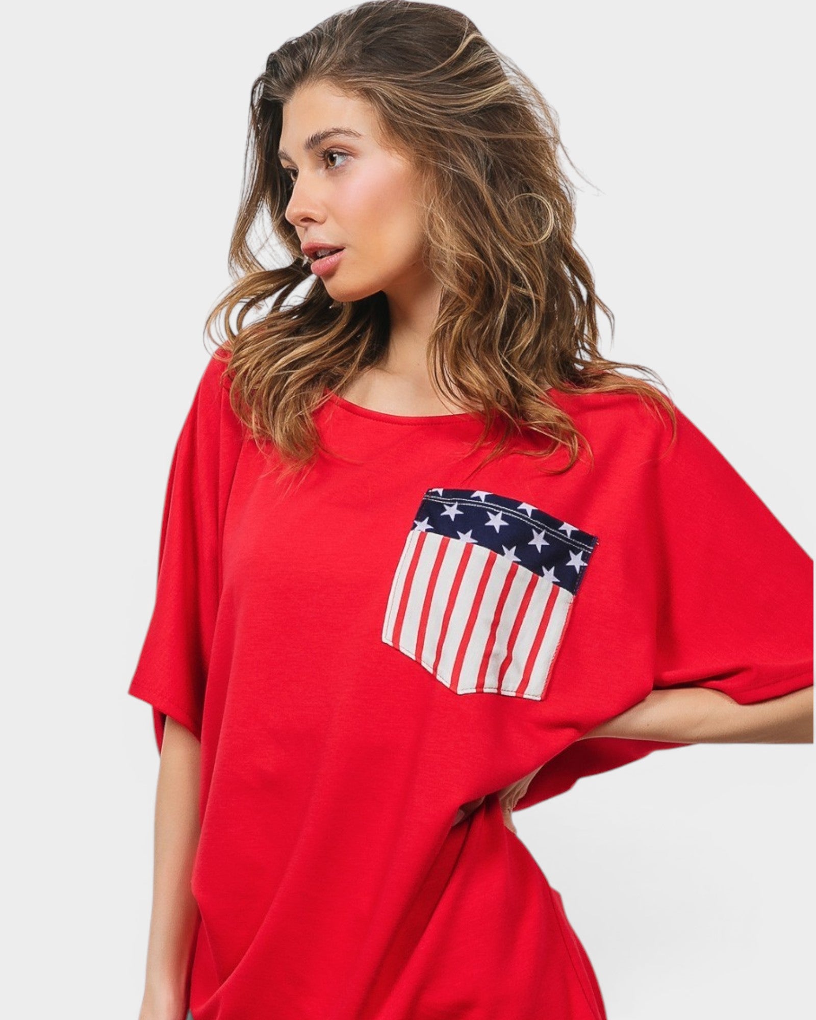Woman wearing a red shirt with an American flag pocket on a white background