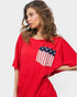 Woman wearing a red shirt with an American flag pocket on a white background