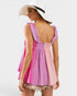 Woman wearing a pink and purple dress with a white hat on a white background