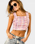 Woman wearing a pink plaid top and denim shorts on a white background