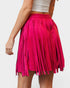 Pink fringed skirt worn by a person on a white background