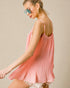 Woman wearing a pink pleated dress with sunglasses on a beige background