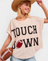 Woman wearing a 'Touchdown' t-shirt with a football graphic, holding a football.