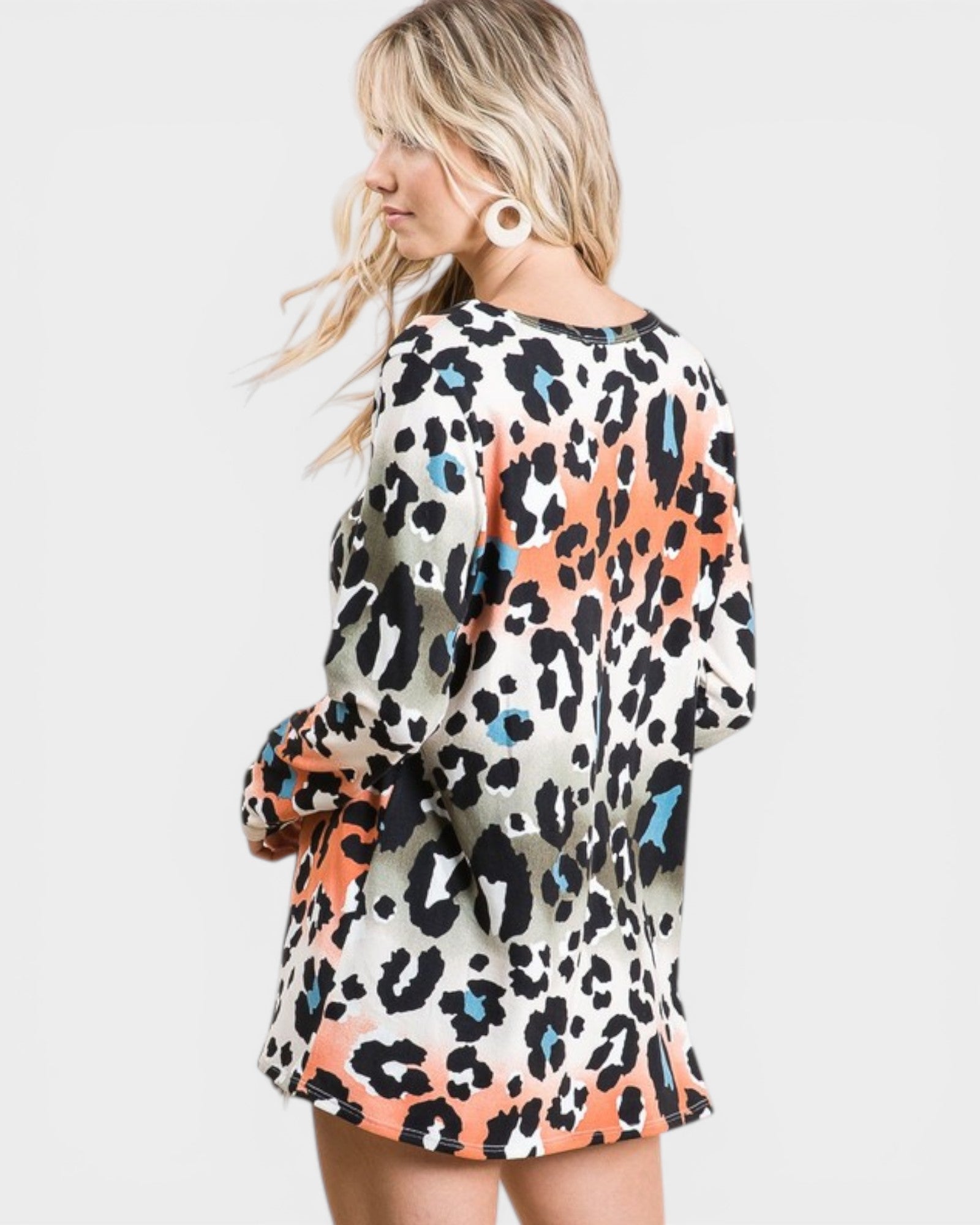 Woman wearing a leopard print dress with colorful patterns on a white background