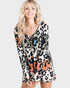 Woman wearing a colorful leopard print dress on a white background