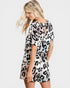 Woman wearing a leopard print romper on a white background