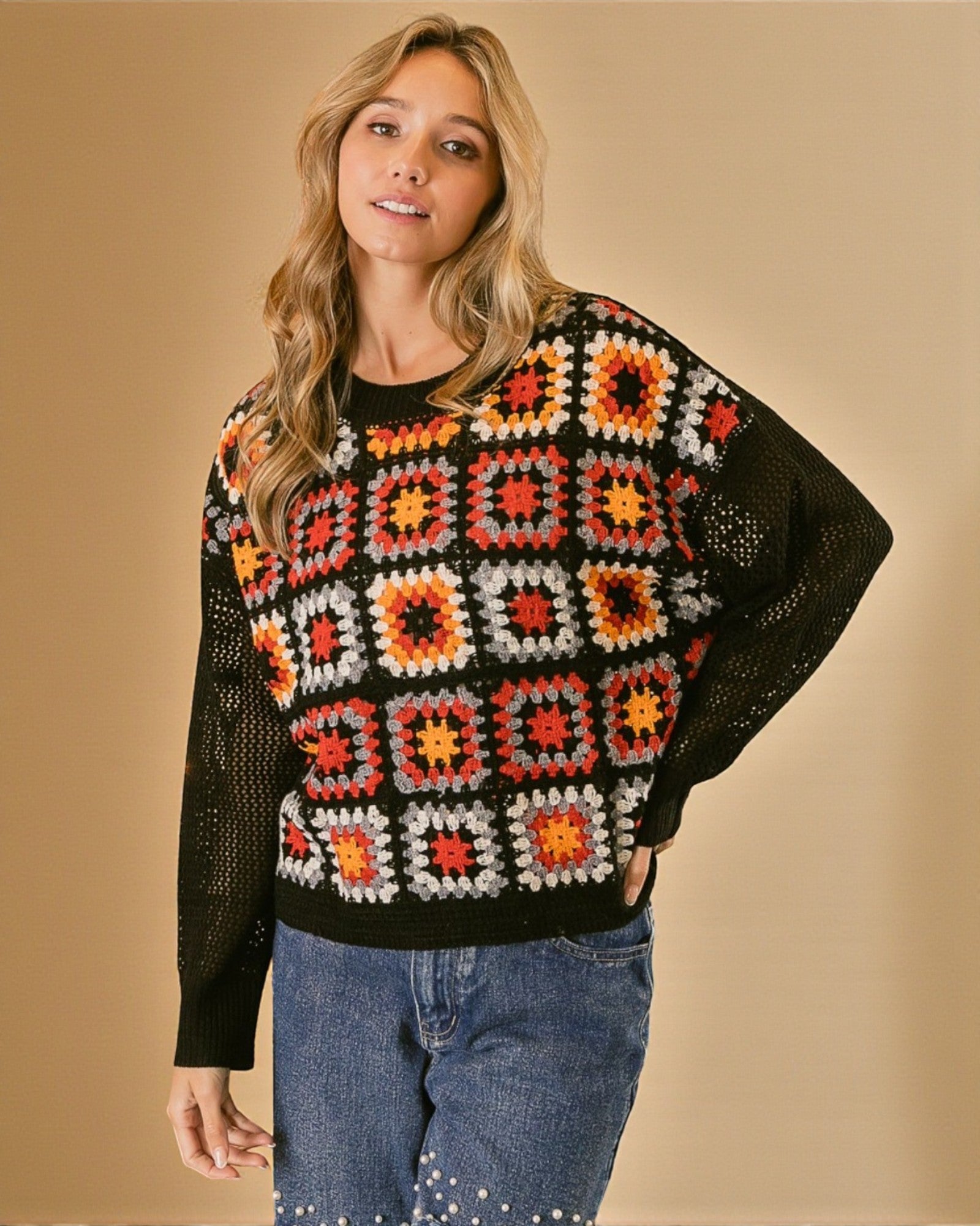 Woman wearing a colorful crochet sweater against a beige background
