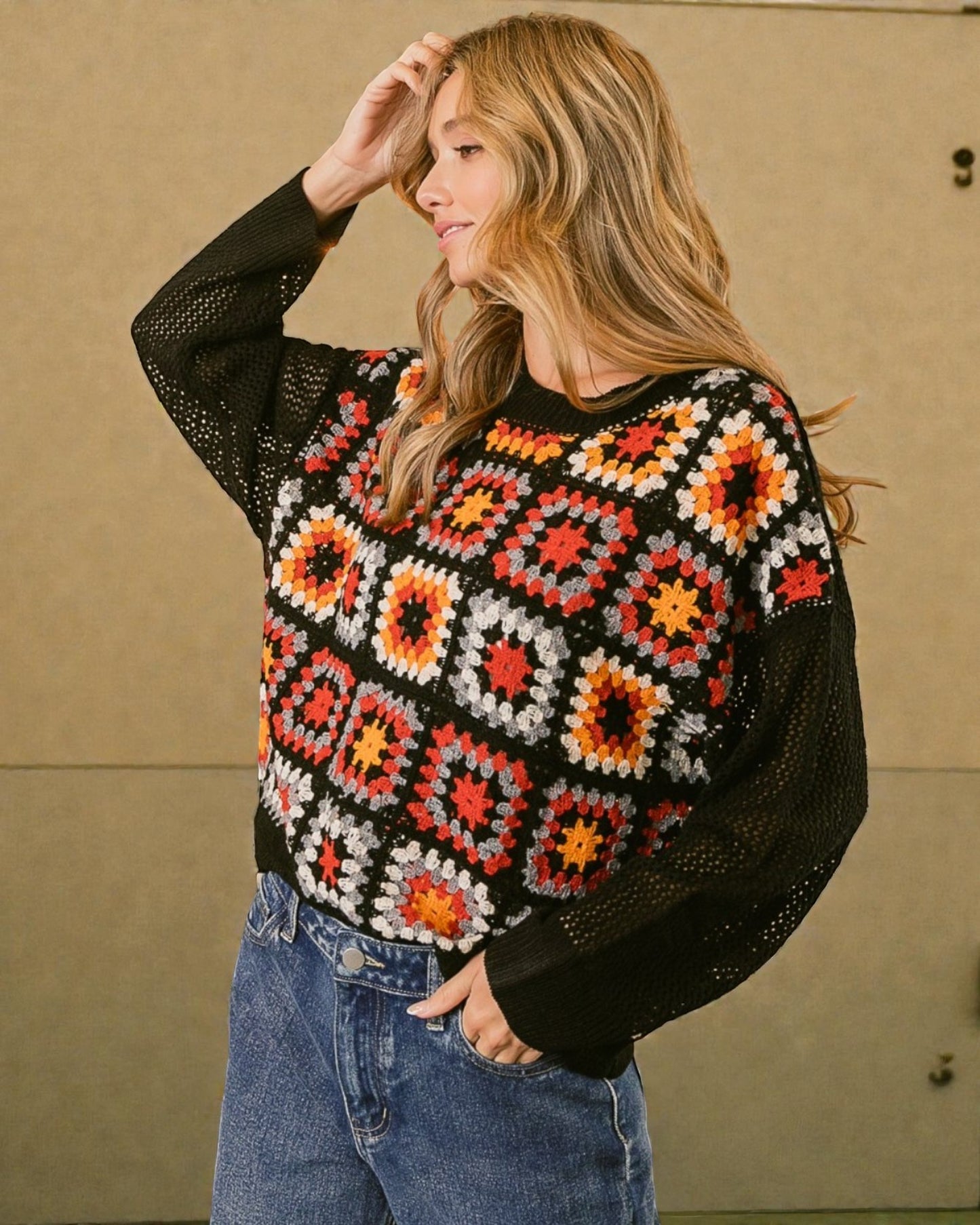 Woman wearing a colorful patterned sweater with a plain background