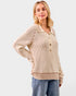 Woman wearing a beige ribbed sweater with buttons on a light gray background