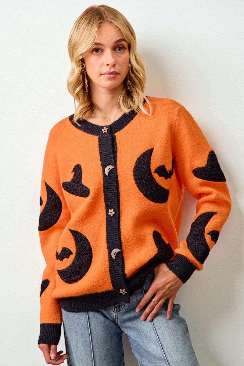 Woman wearing an orange sweater with black cat patterns on a white background