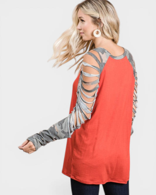Woman wearing a red long-sleeve top with gray cut-out sleeves on a white background