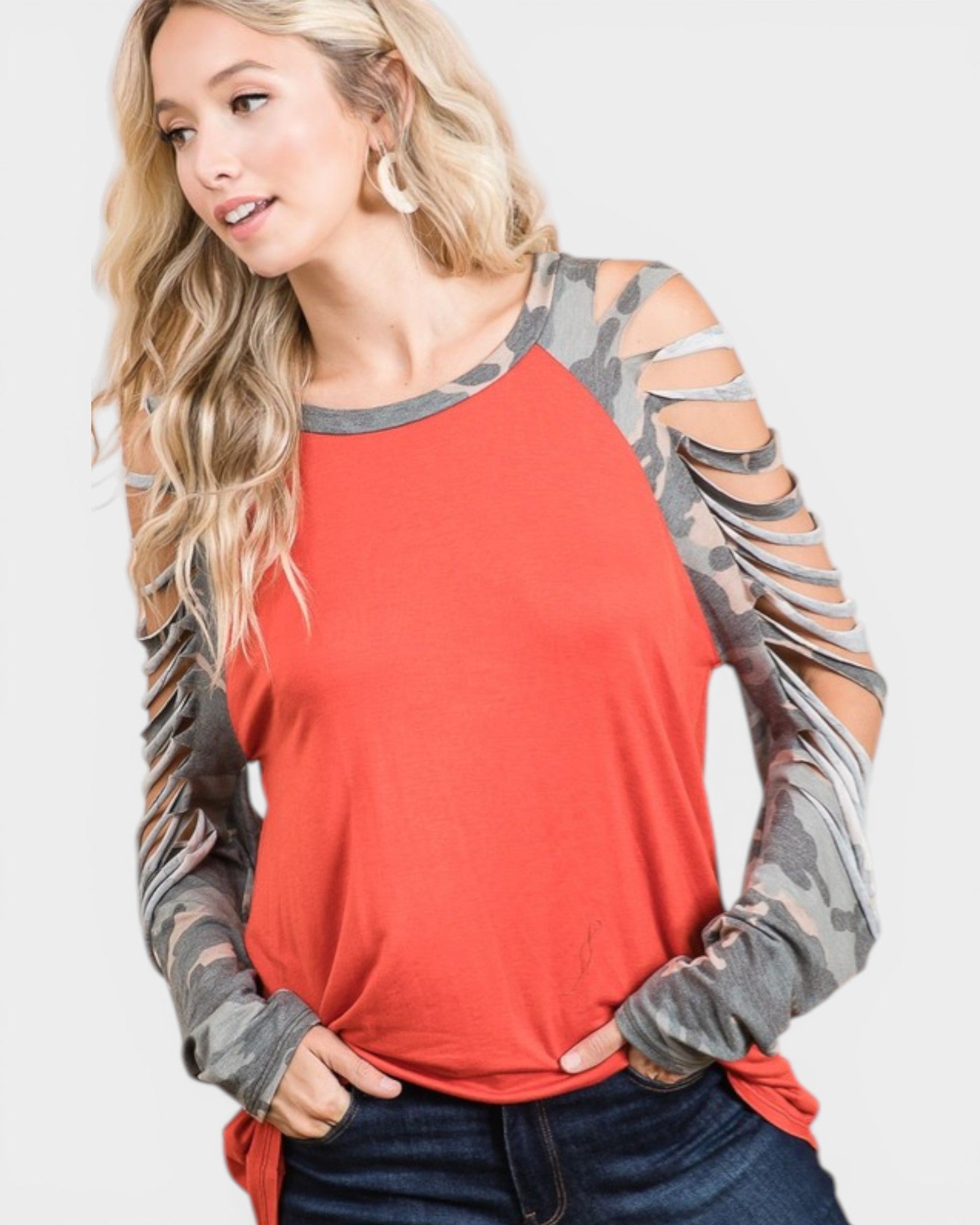 Woman wearing a red long-sleeve top with camouflage sleeves on a white background