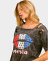 Woman wearing a distressed t-shirt with a graphic design and 'merica text on a plain background