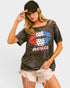 Woman wearing a graphic t-shirt with 'Merica' design and a cap on a light gray background