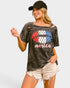Woman wearing a graphic t-shirt with 'America' and an American flag design on a plain background