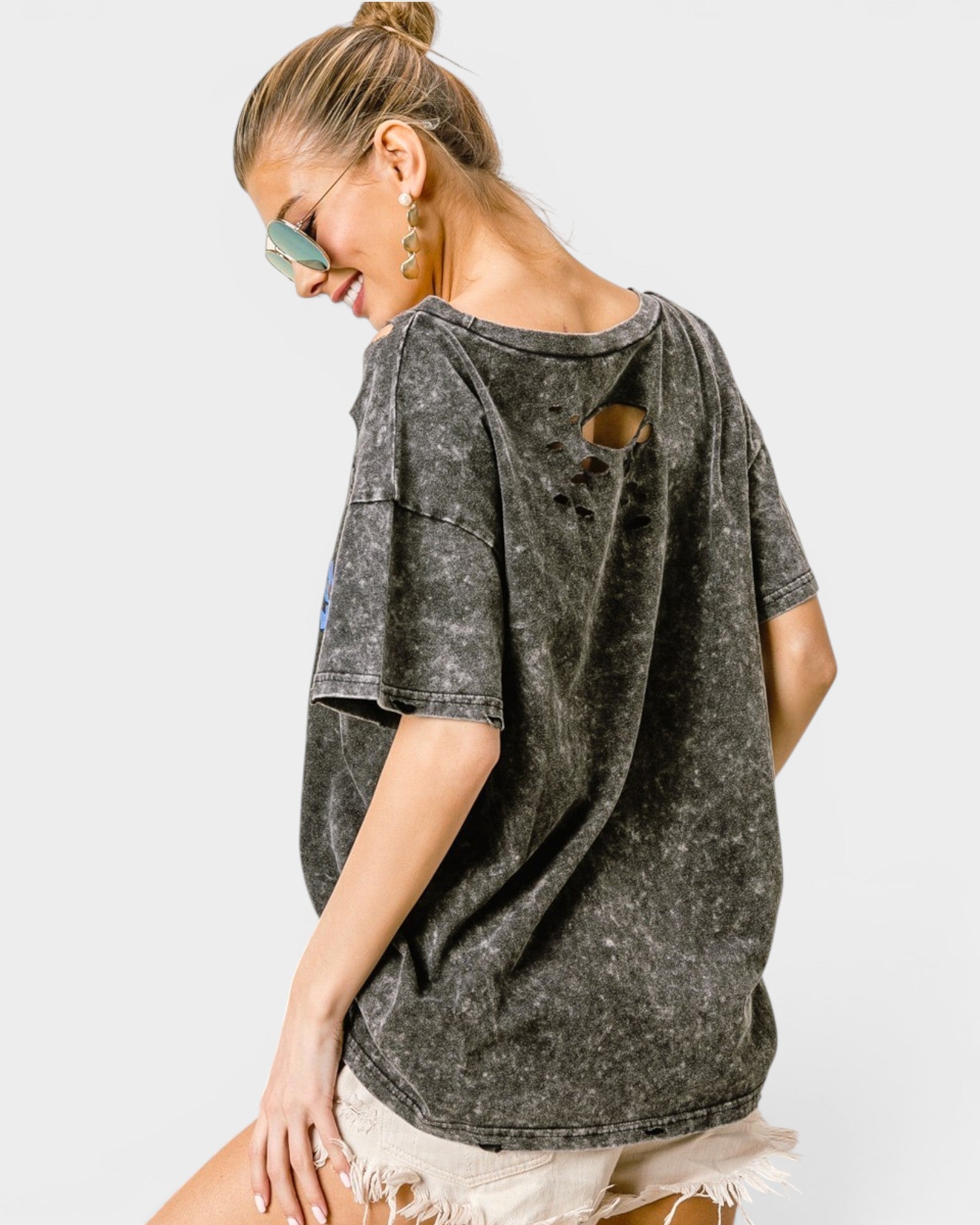 Woman wearing a distressed black t-shirt on a white background