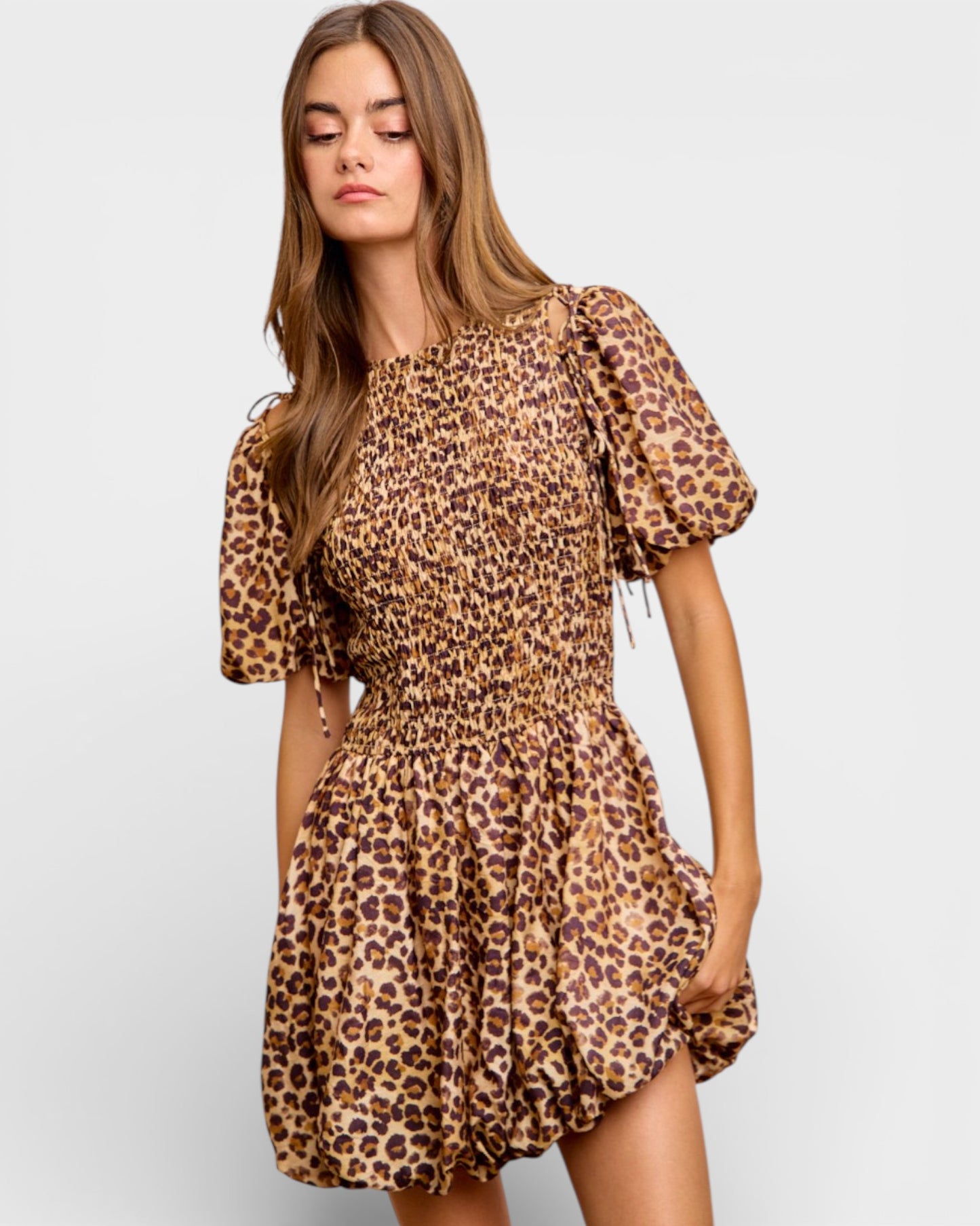 Woman wearing a leopard print dress on a light gray background