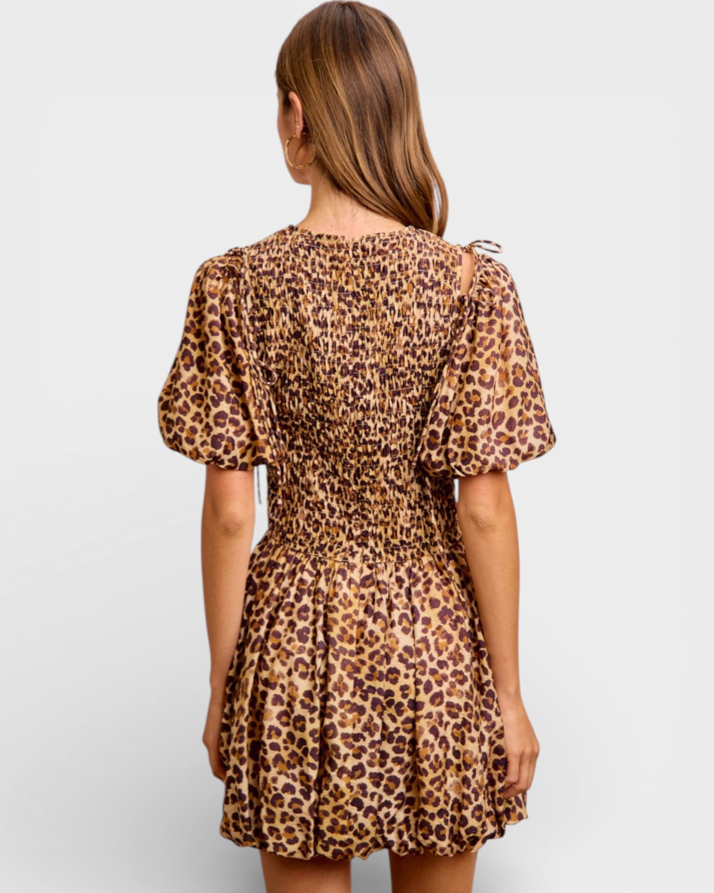 Woman wearing a leopard print dress on a white background