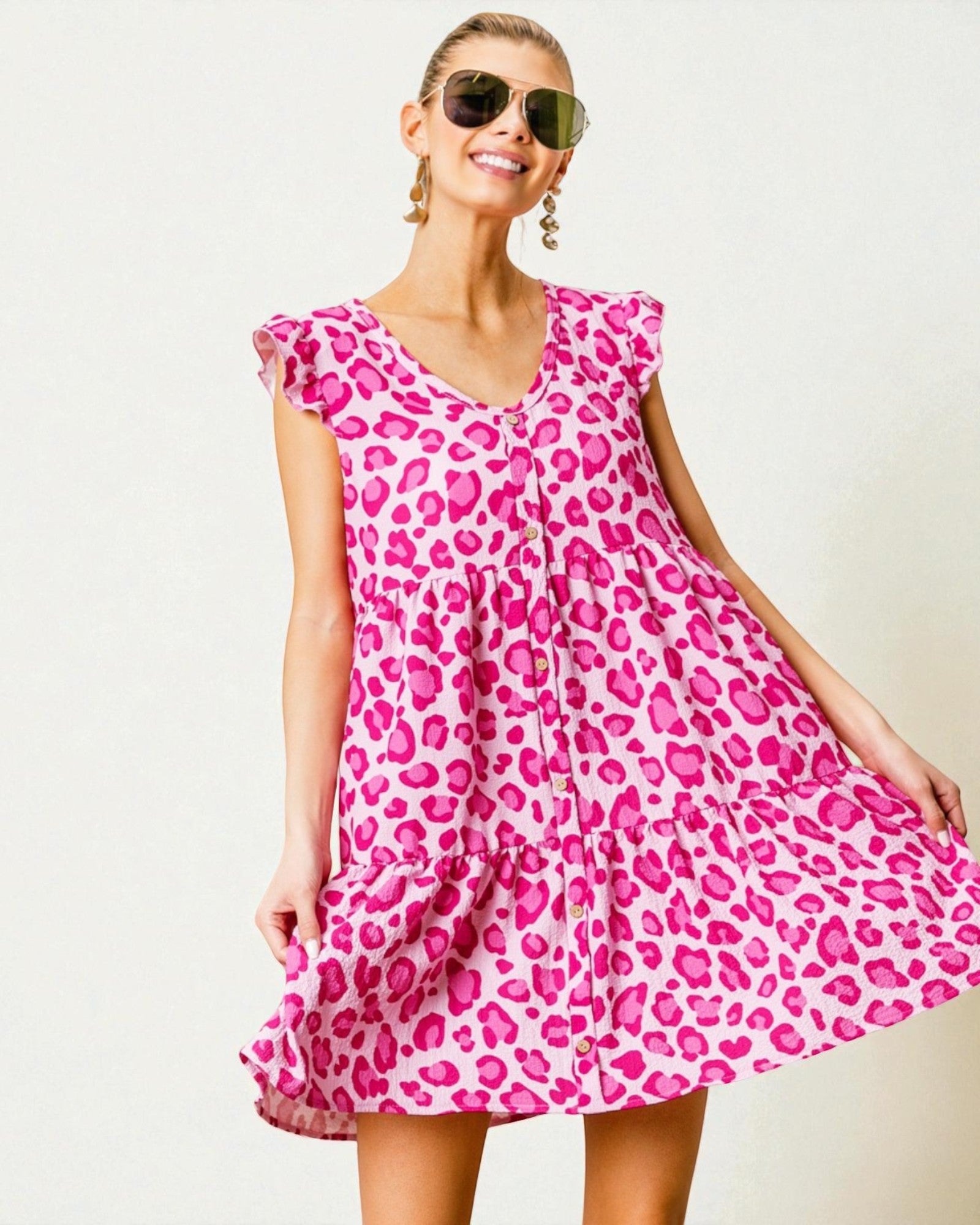 Woman wearing a pink leopard print dress against a white background