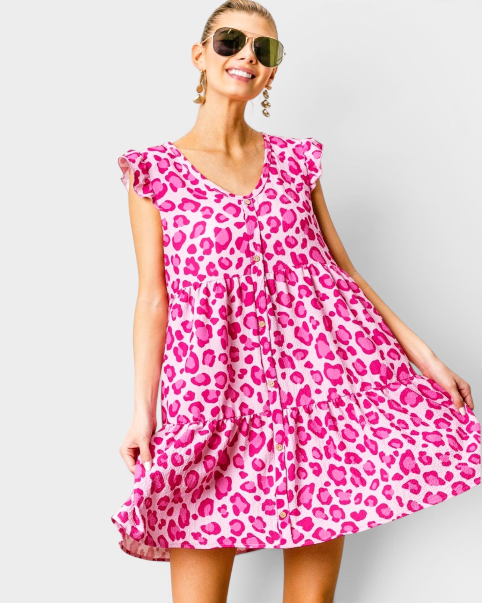 Woman wearing a pink leopard print dress against a white background