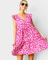Woman wearing a pink leopard print dress against a white background