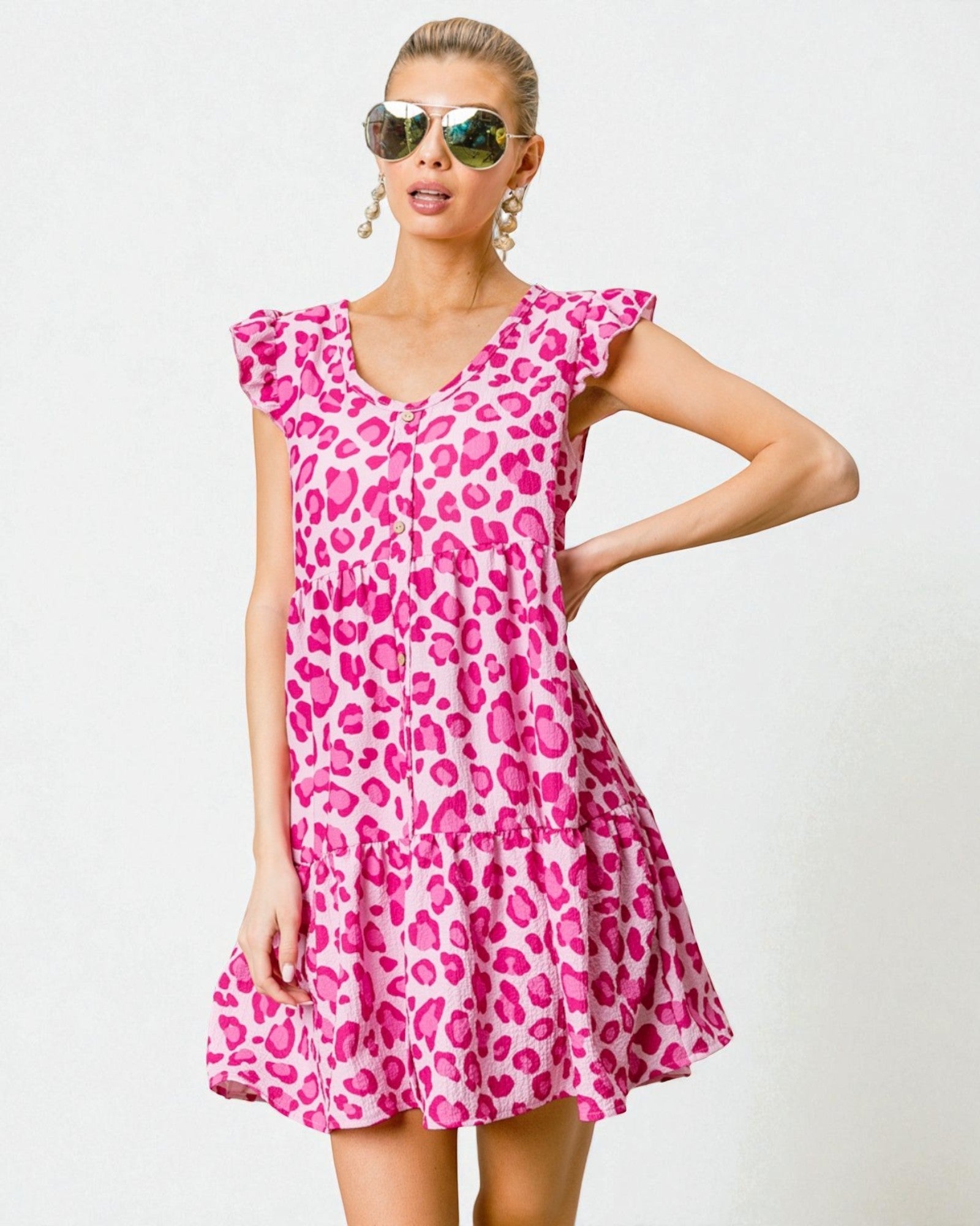 Woman wearing a pink leopard print dress against a white background
