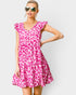 Woman wearing a pink leopard print dress on a white background