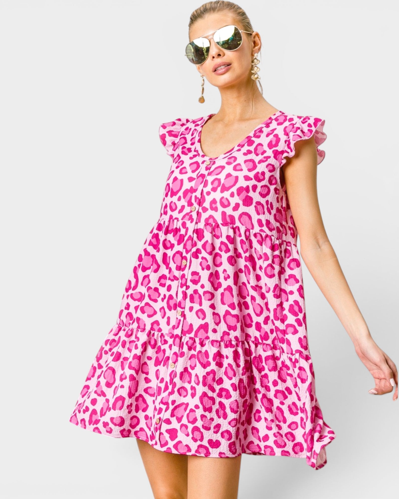 Woman wearing a pink leopard print dress against a white background
