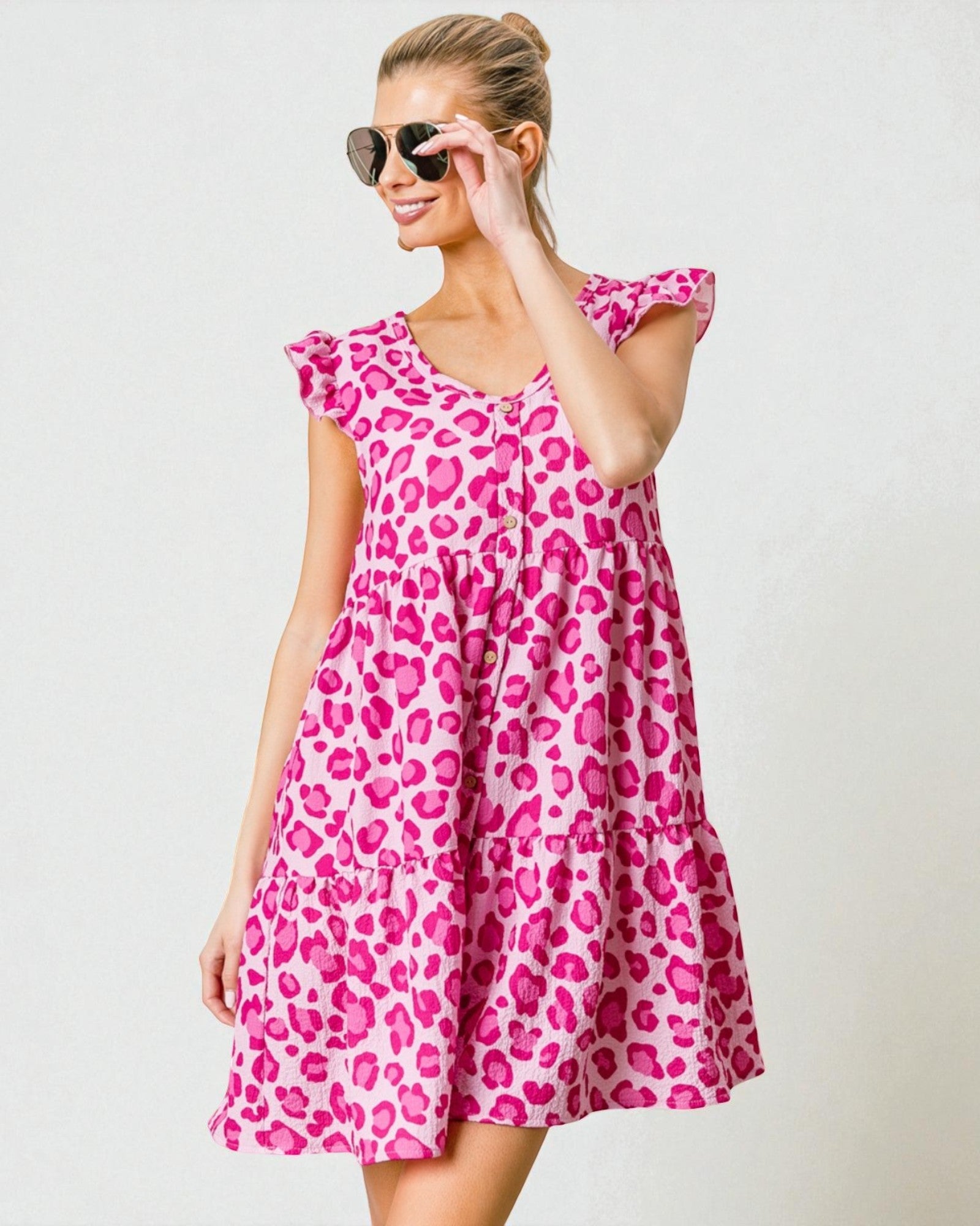 Woman wearing a pink leopard print dress against a white background