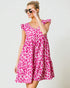 Woman wearing a pink leopard print dress against a white background