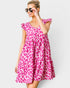 Woman wearing a pink leopard print dress against a white background