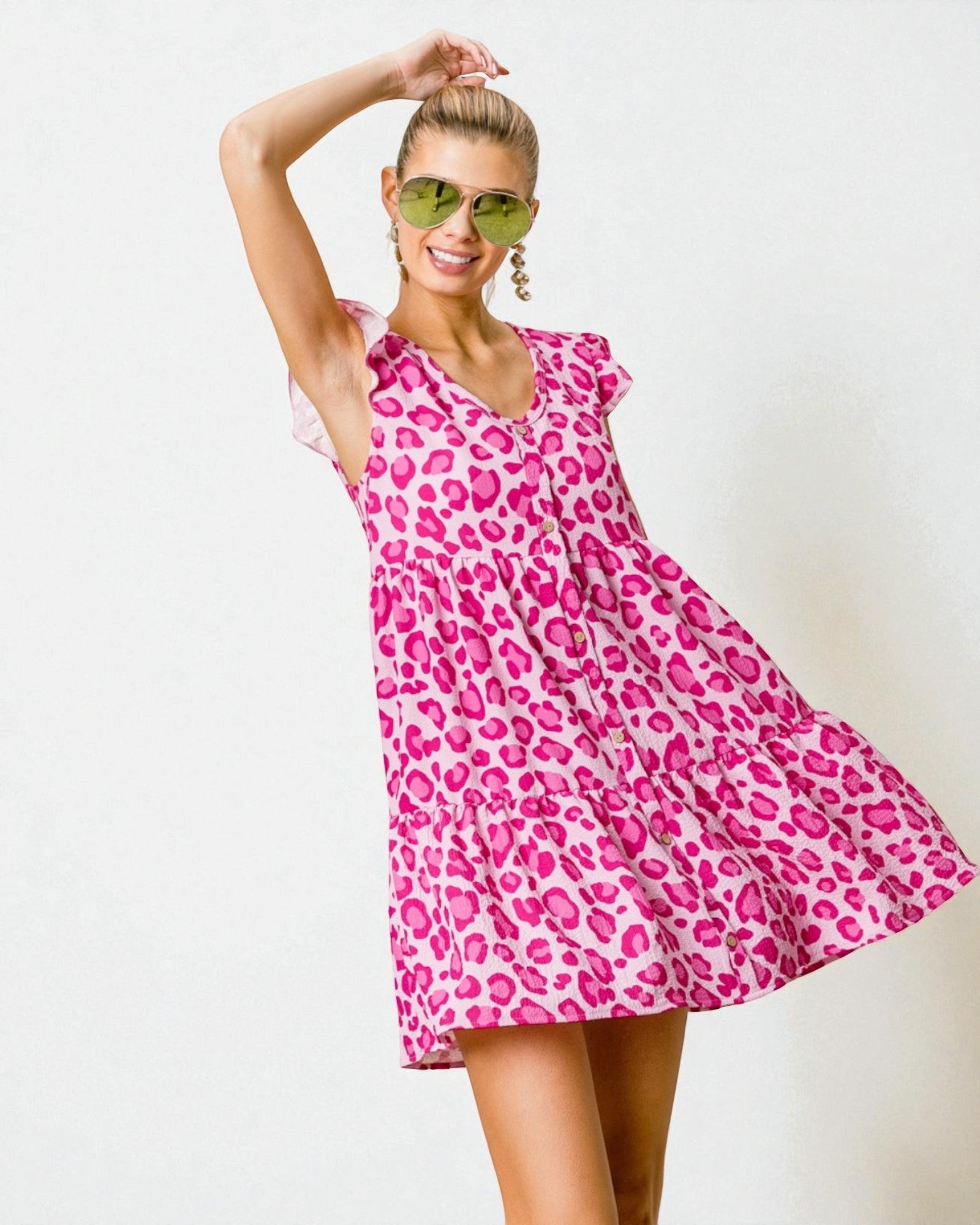 Woman wearing a pink leopard print dress against a white background