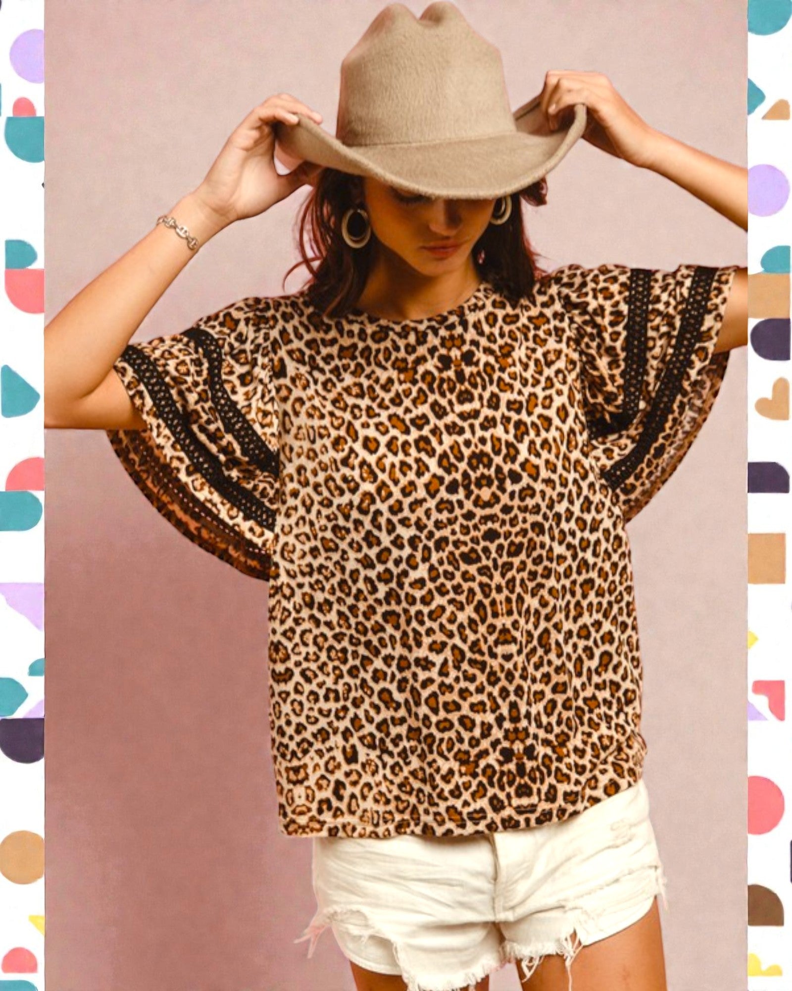 Person wearing a leopard print top with black trim and a beige hat against a colorful background