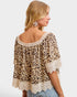 Woman wearing a leopard print top with lace details on a white background