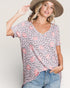 Woman wearing a patterned shirt and hat on a plain background