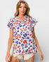 Woman wearing a colorful leopard print top on a white background