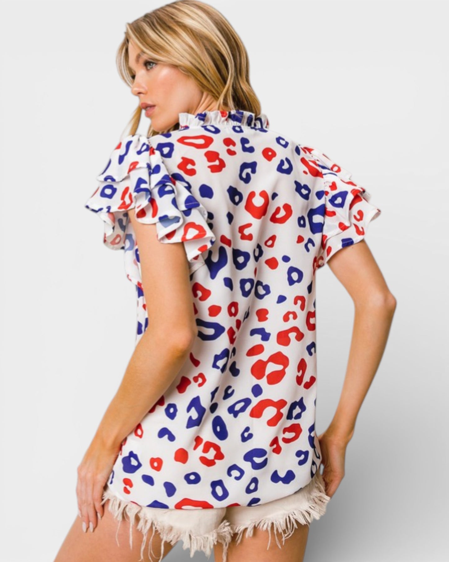Woman wearing a colorful leopard print top with a white background