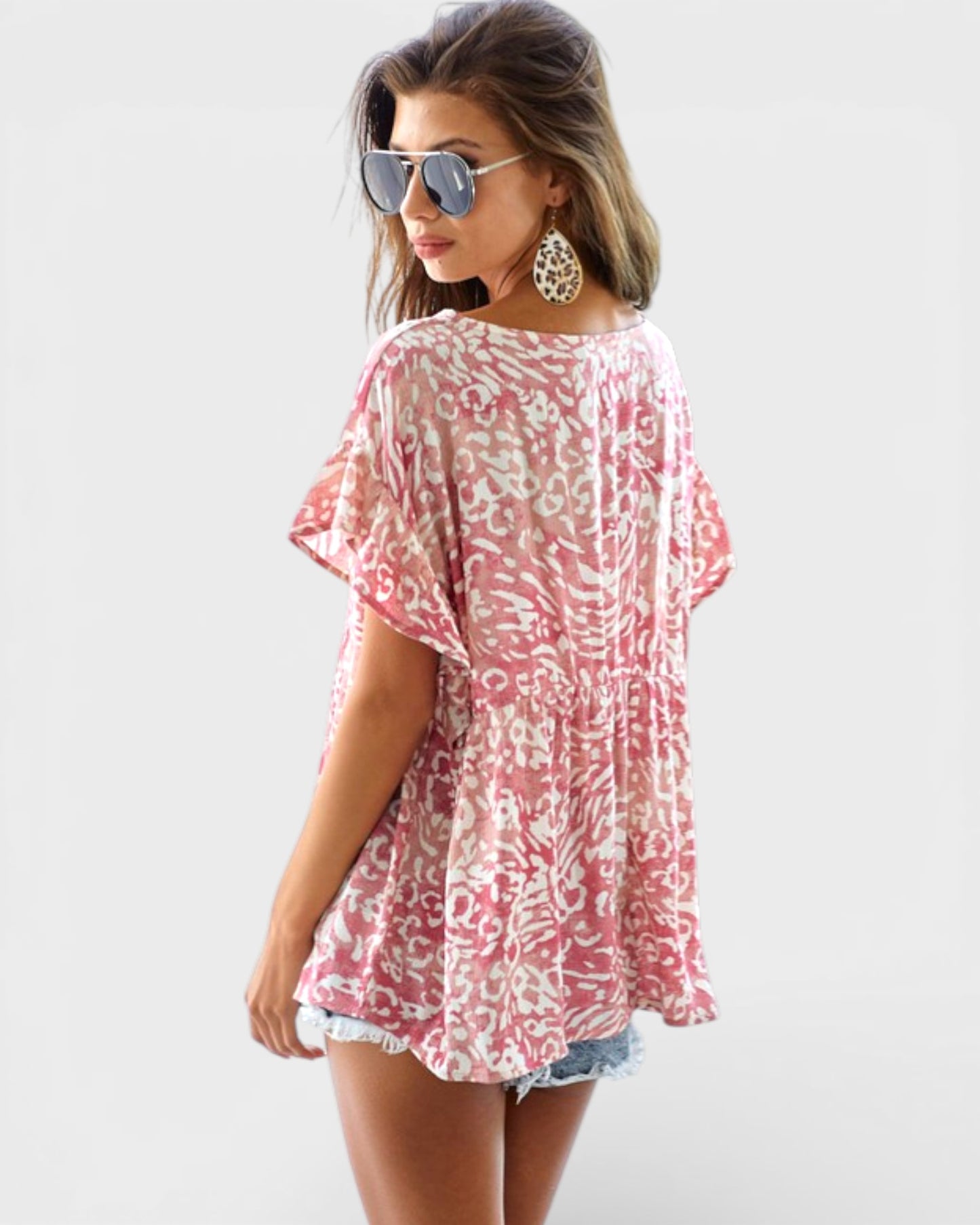 Woman wearing a pink floral cover-up on a white background