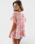 Woman wearing a pink floral cover-up on a white background