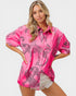 Woman wearing a pink shirt with leopard print design on a white background