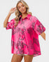 Woman wearing a pink shirt with black animal print on a white background