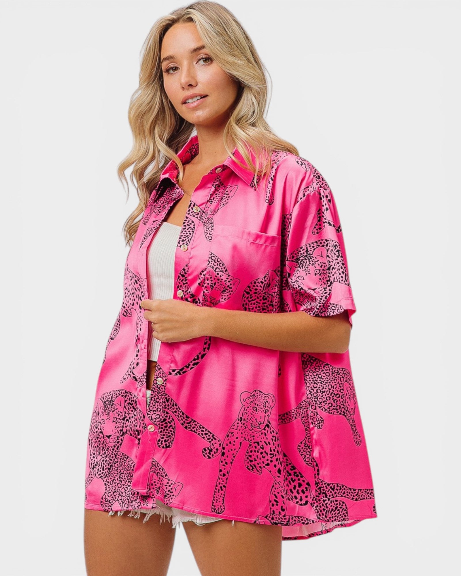 Woman wearing a pink satin robe with leopard print design on a white background