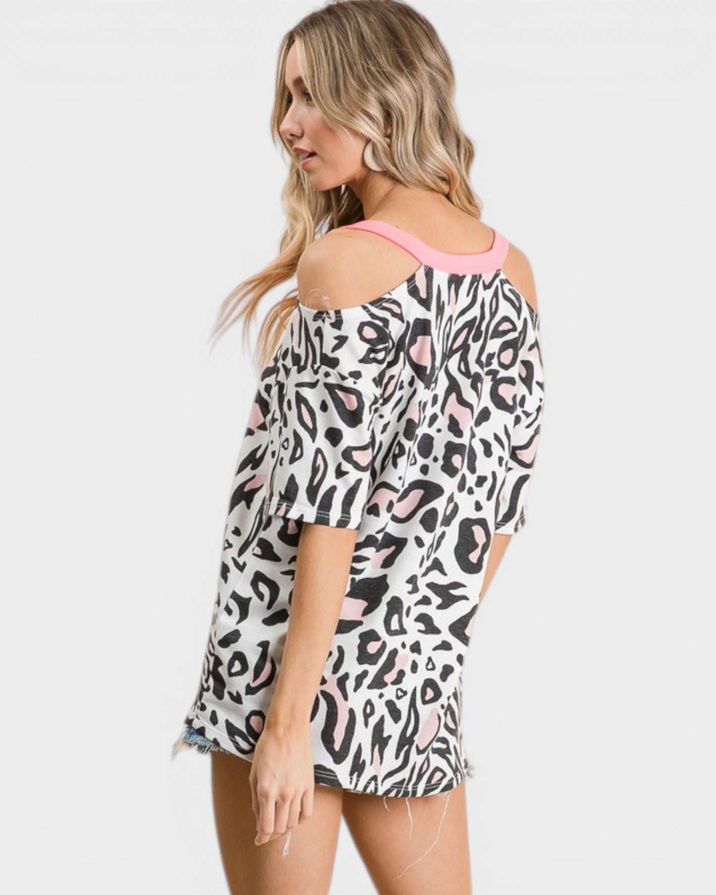 Woman wearing a leopard print off-shoulder top on a white background