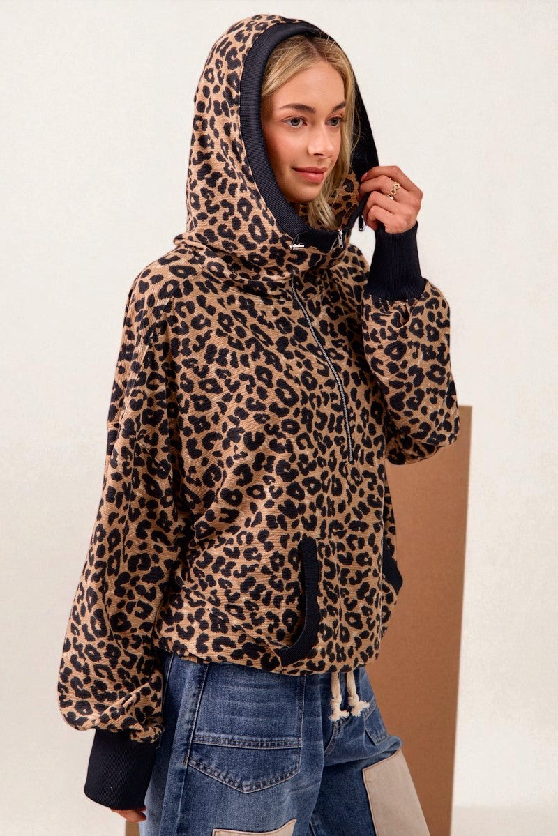 Person wearing a leopard print hoodie with a plain background