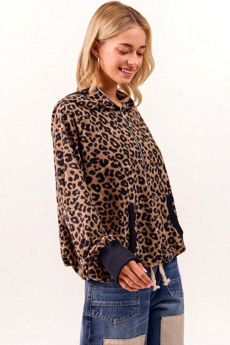 Woman wearing a leopard print jacket and jeans on a white background