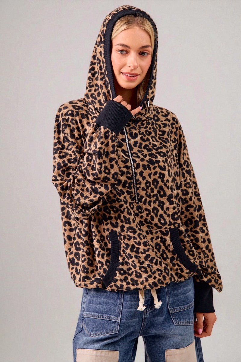 Person wearing a leopard print hoodie with a plain background